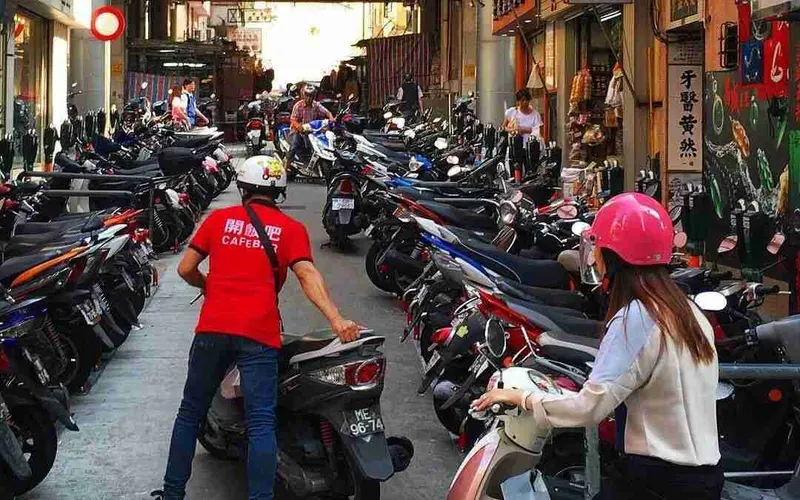 Calle llena de motos en una ciudad asiática