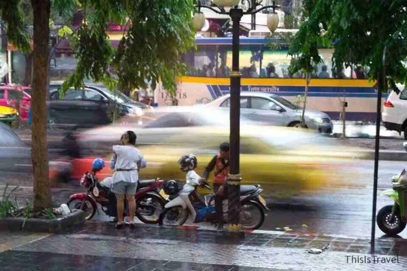 Motos y tráfico en una calle de Bangkok tras la lluvia