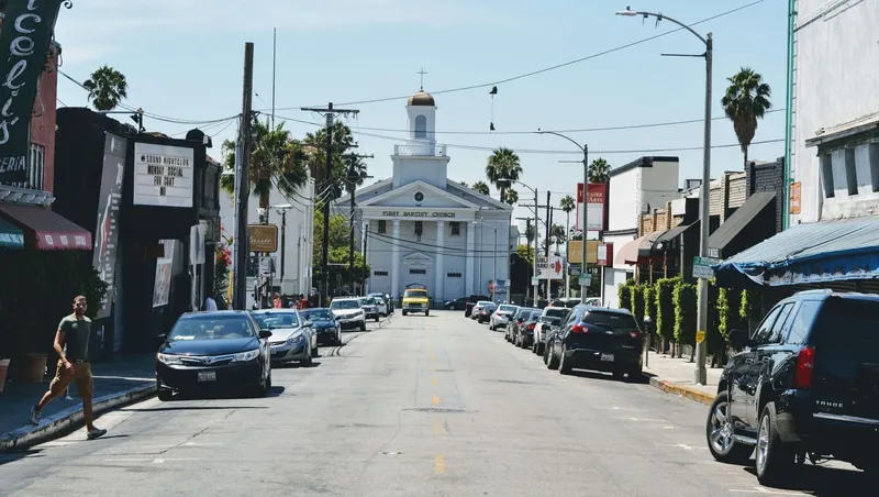Calle de Beverly Hills con un edificio blanco de cúpula al fondo