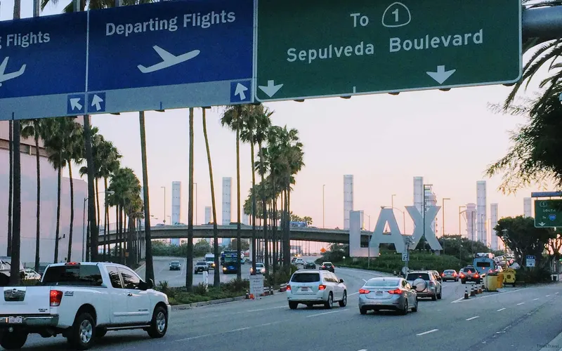 Letrero de LAX y el cartel de salidas del aeropuerto de Los Ángeles