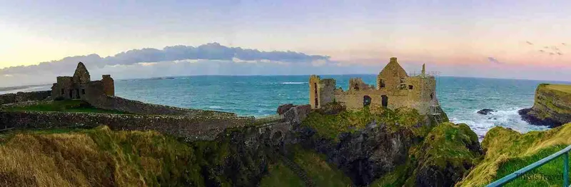 Las ruinas del castillo de Dunluce al borde del acantilado, al atardecer