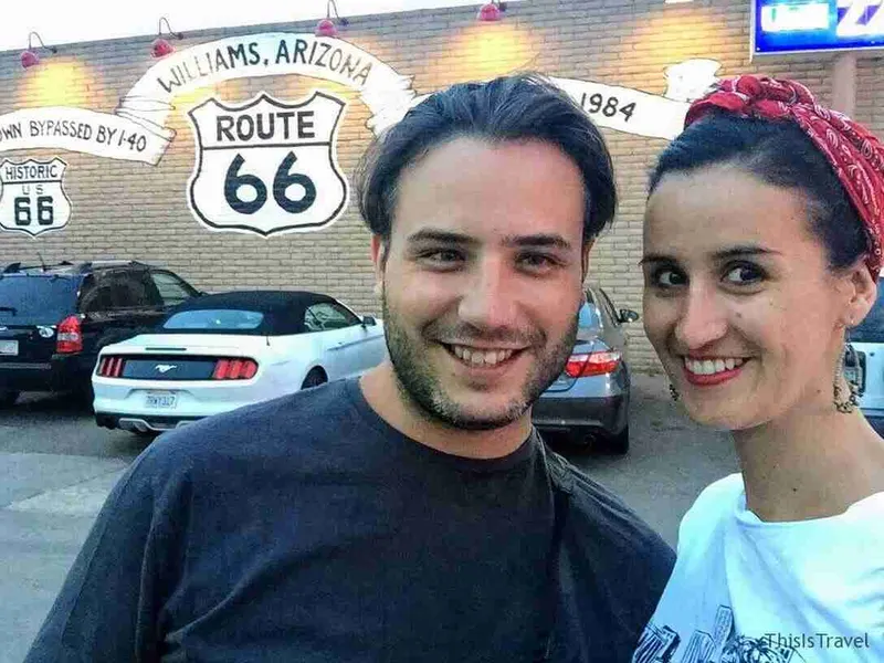 Pareja ante el cartel de la Ruta 66 en Williams, Arizona