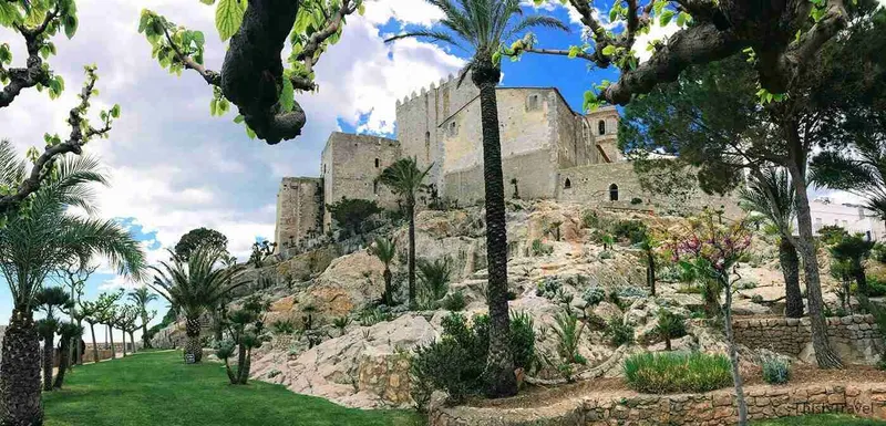 Murallas del castillo del Papa Luna entre palmeras, en Peñíscola