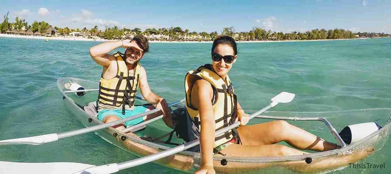 Pareja con chaleco en un kayak transparente en las aguas de Mauricio