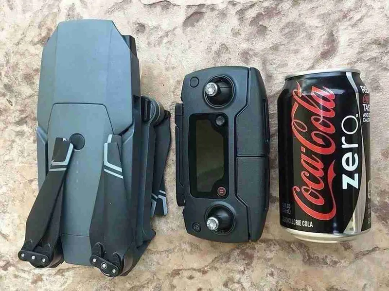 Dron DJI Mavic plegado junto a su mando y una lata de refresco, para ver el tamaño