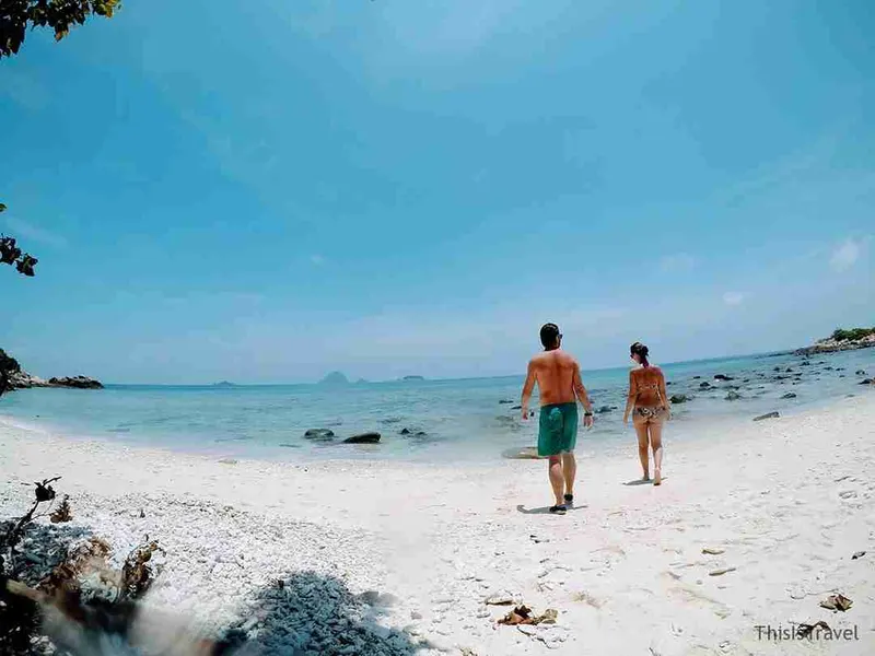 Pareja paseando por la arena blanca de una playa de las Perhentian