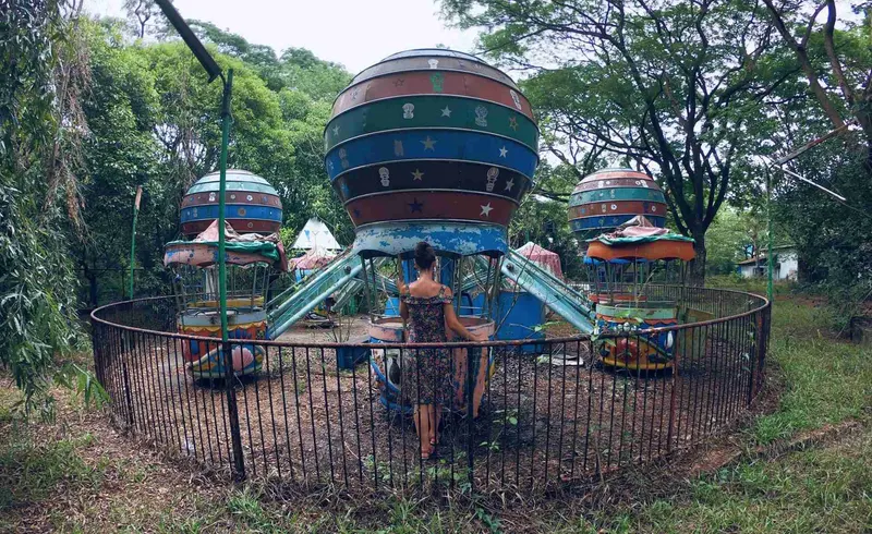 Atracción con forma de platillo volante, oxidada entre los árboles