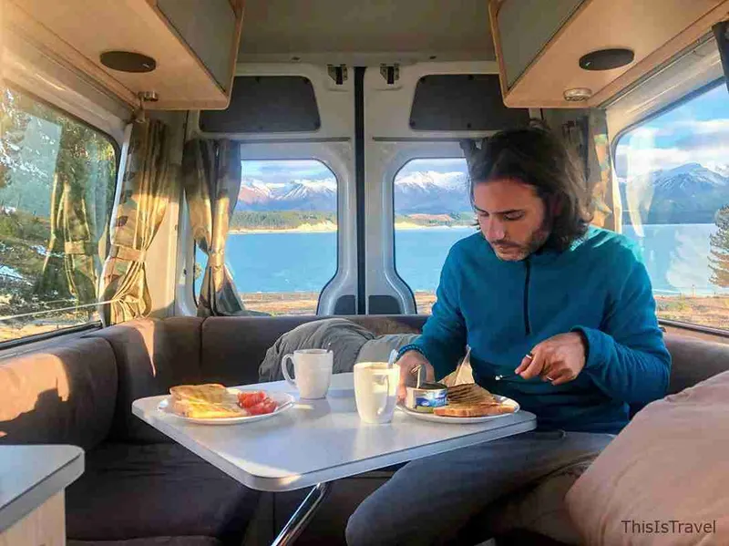 Desayuno dentro de la campervan, con el lago al otro lado de la ventana