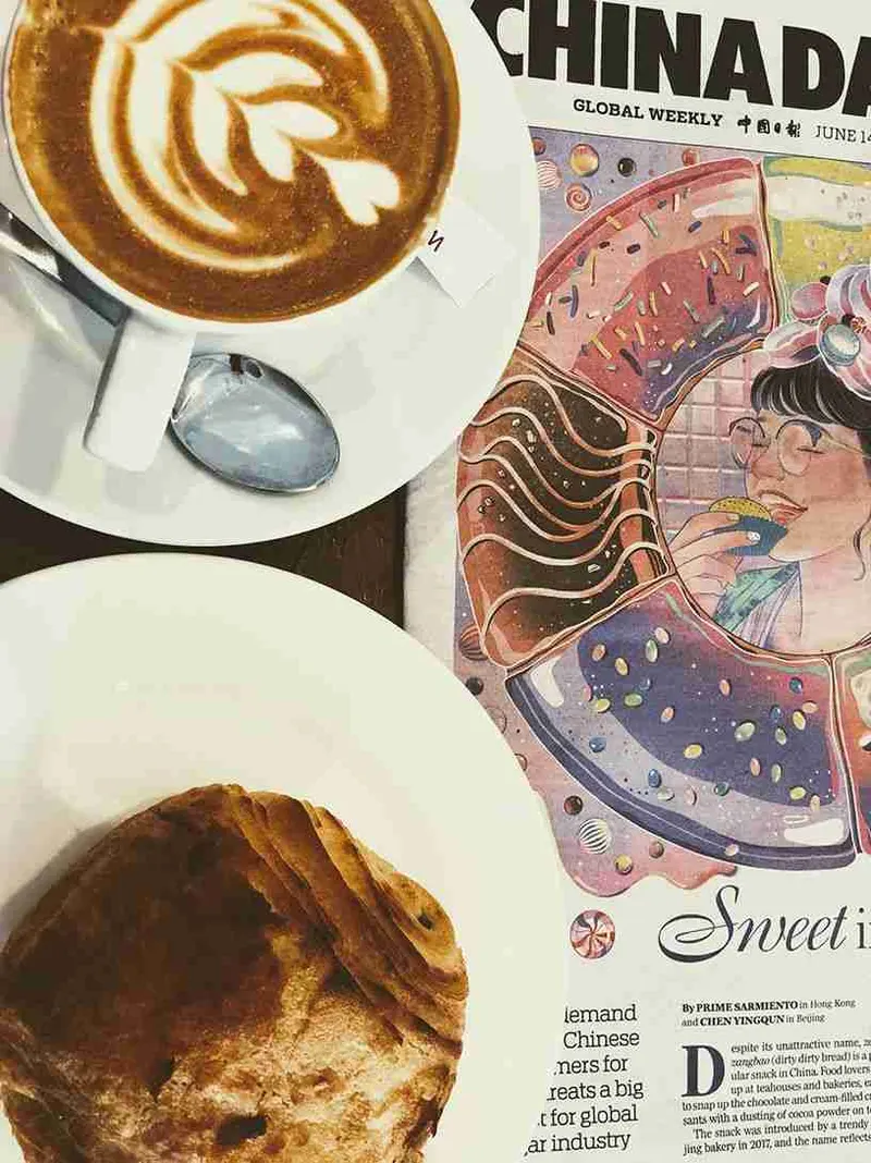 Café con arte en la leche sobre una mesa del Anomali, en Ubud