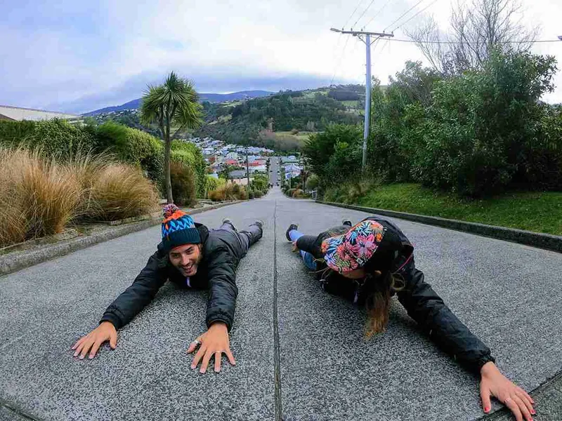 Dos personas tumbadas en la empinada calle Baldwin de Dunedin