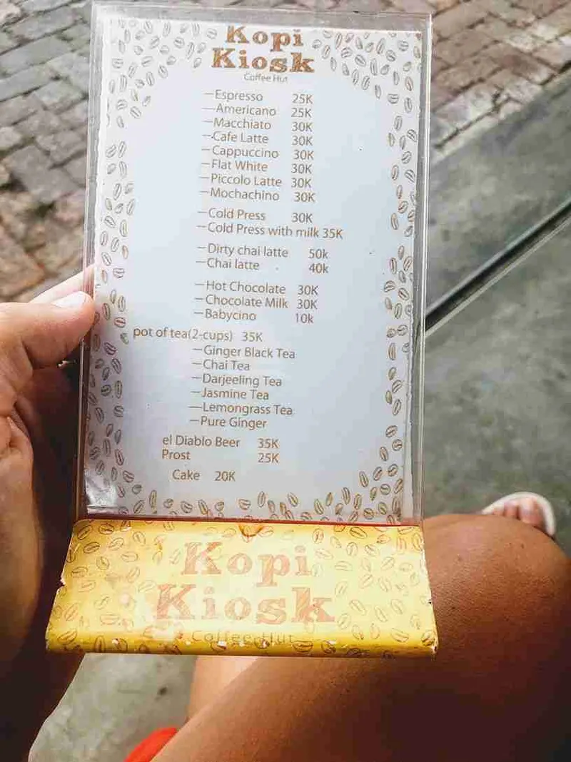La carta del Kopi Kiosk en la mano