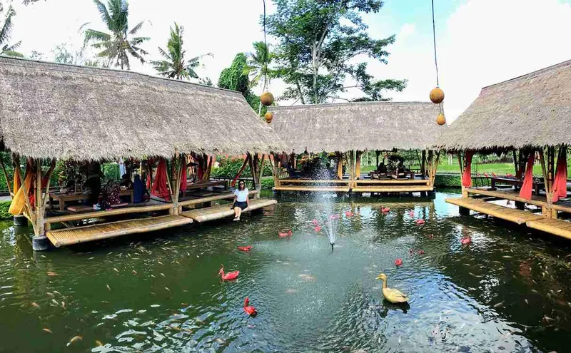 Cabañas de paja sobre el estanque del restaurante Bale Udang