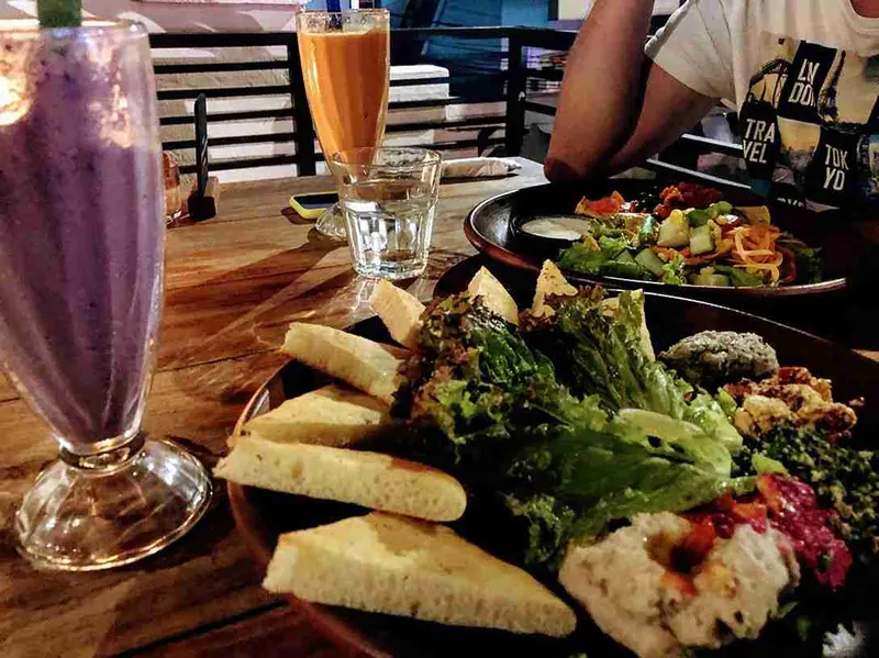 Mesa del Bali Buda con panes, ensalada y bebidas