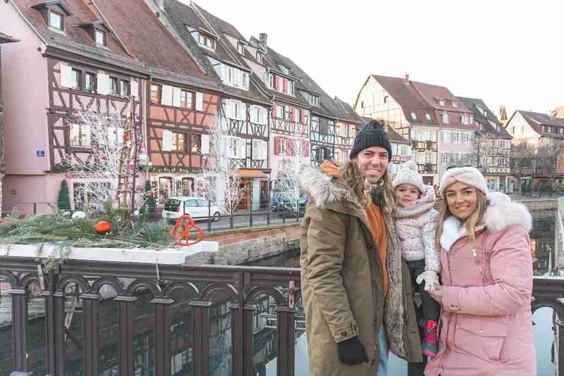 Familia abrigada ante las casas de colores de Colmar, en Alsacia