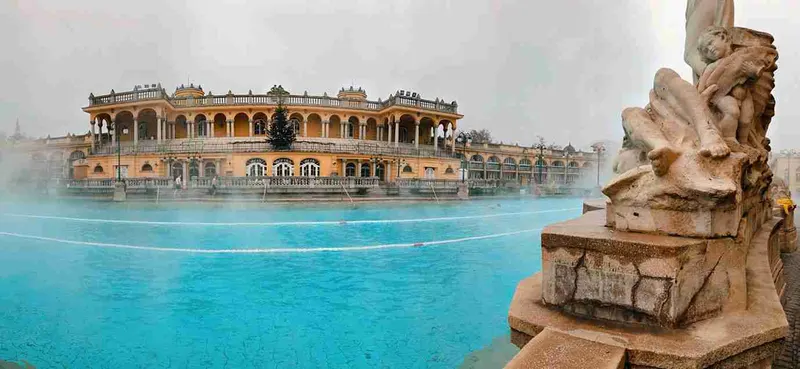 Las piscinas exteriores y el edificio amarillo de las termas Széchenyi