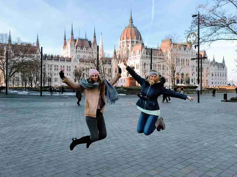 Dos personas saltando delante del Parlamento de Budapest