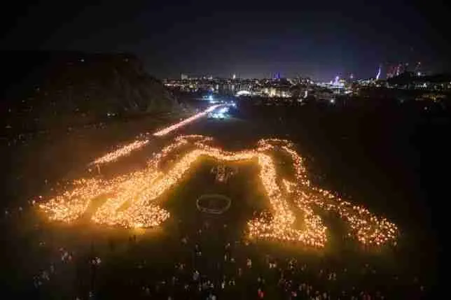 Procesión de antorchas del Hogmanay vista desde el aire, dibujando una figura de noche sobre Edimburgo