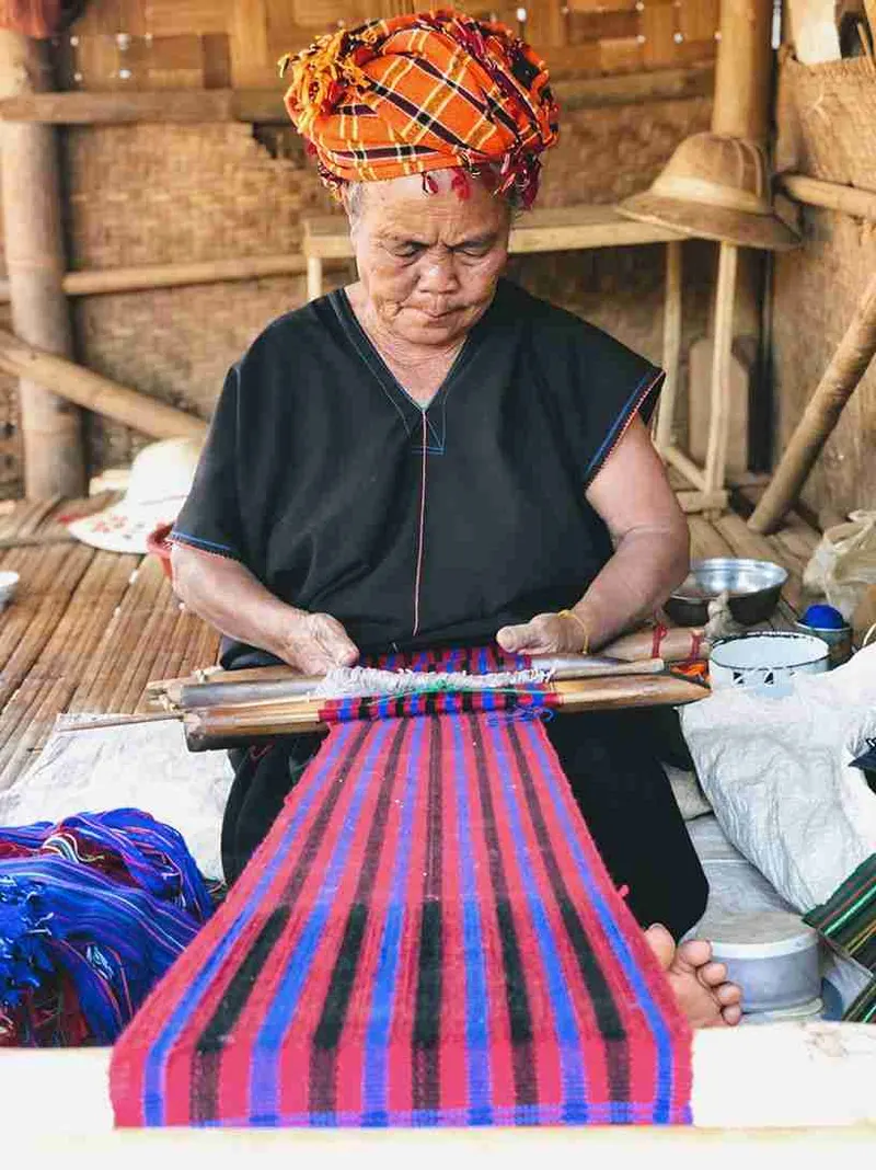 Mujer tejiendo en un telar tradicional de Myanmar