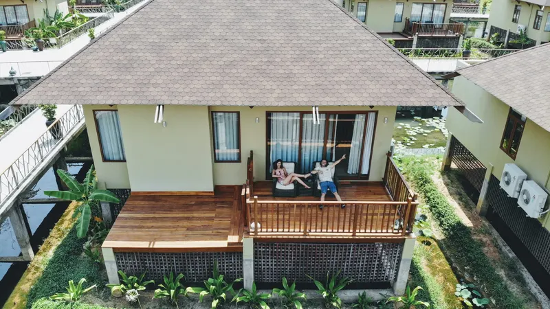 Bungalow de madera con porche y hamacas, rodeado de vegetación