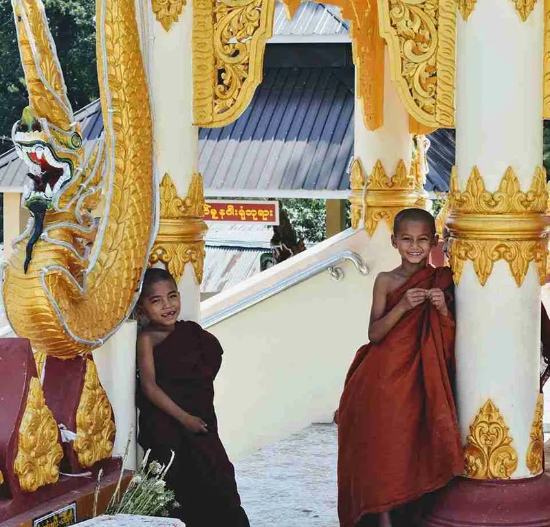 Dos monjes novicios en el pórtico dorado de una pagoda