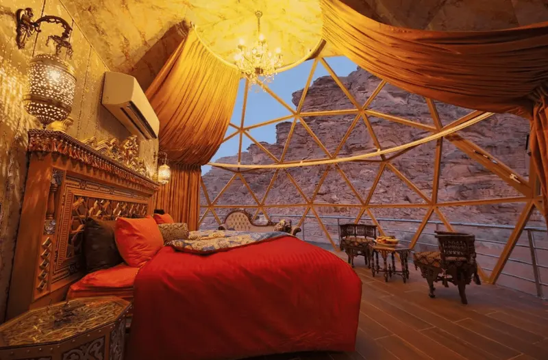 Interior de una burbuja del campamento Memories Aicha, con la pared de roca del Wadi Rum al otro lado del cristal
