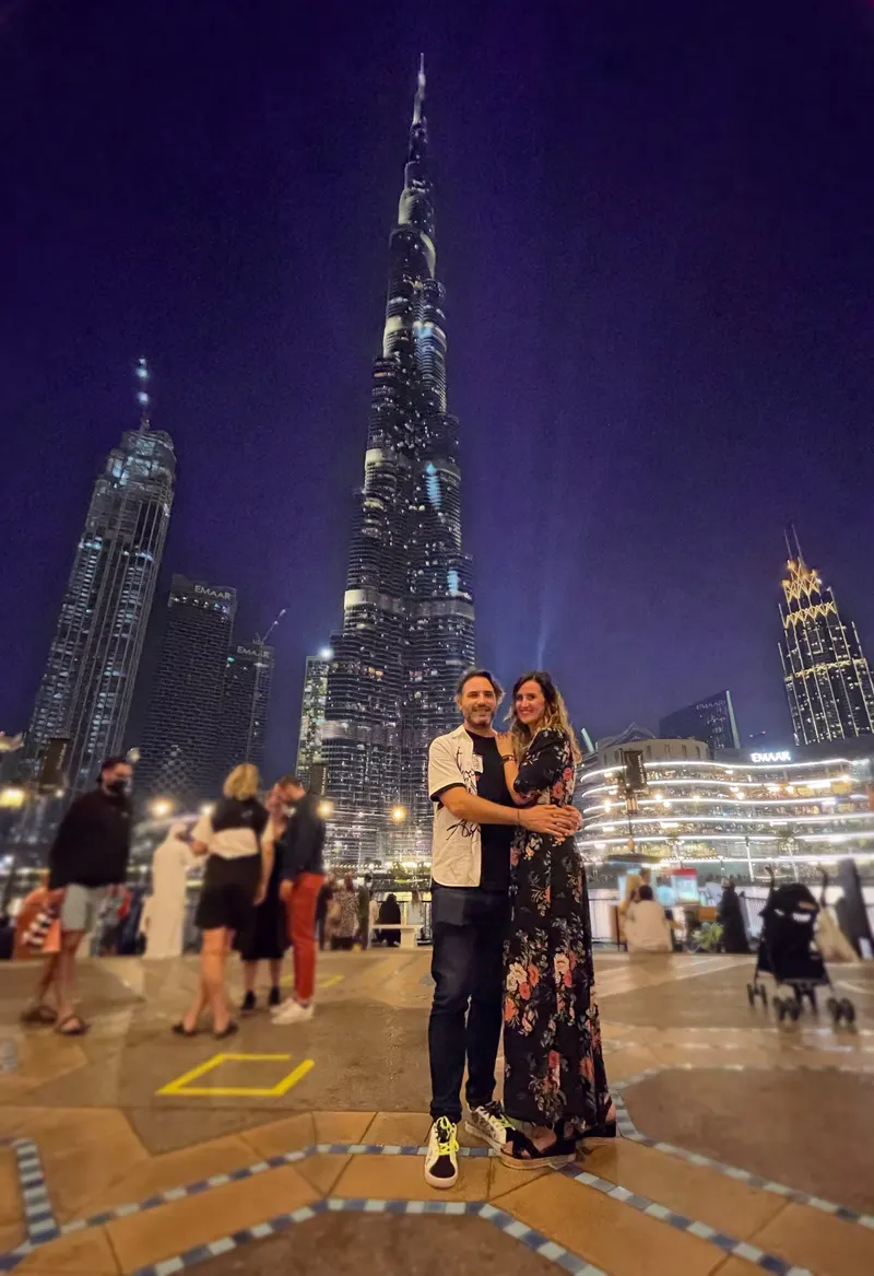 Pareja posa bajo el Burj Khalifa de noche