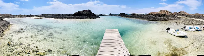 panoramica de la isla de Lobos con su formación volcánica y su puerto, agua turquesa