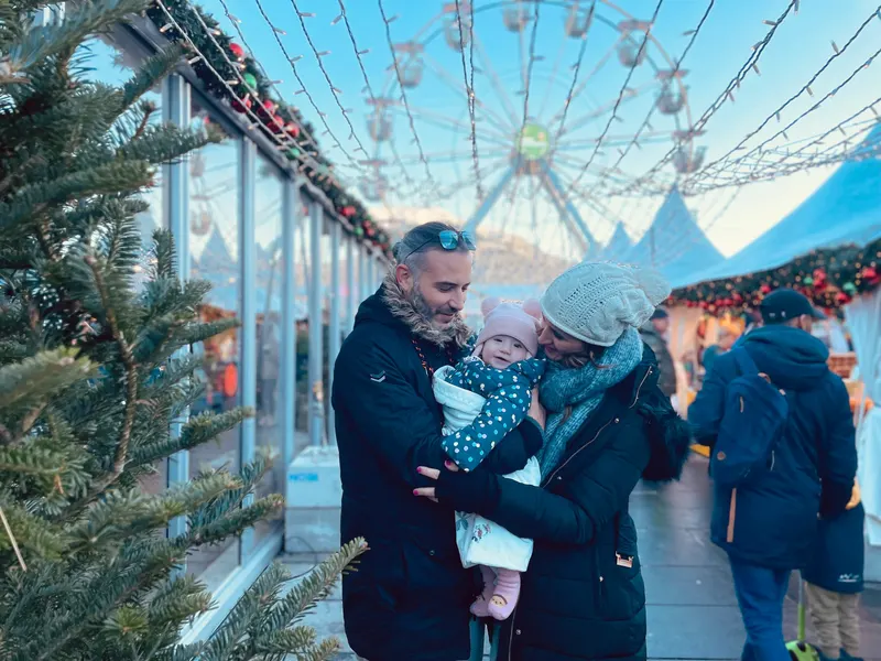 mercado de Navidad de Bergen, familia de ThisIsTravel con el fondo de la noria y el mercado de invierno