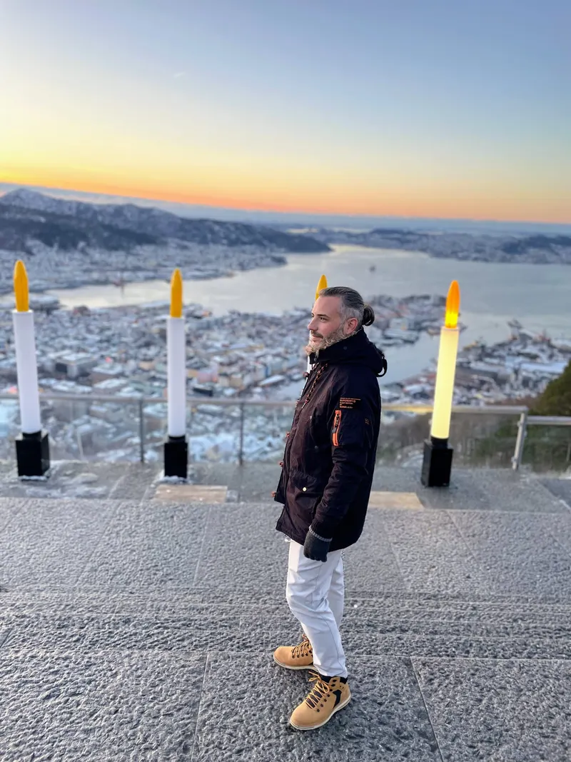 Detalle de Kike de ThisIsTravel en Monte Floyen al atardecer en Navidad con el calendario de adviento a sus espaldas, Bergen