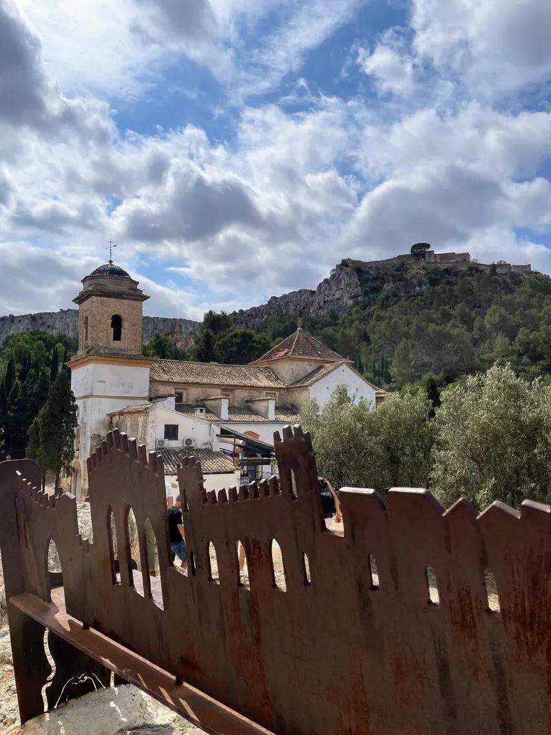 panoramica del castillo de Xàtiva, tras un banco con la panoramica de la ciudad