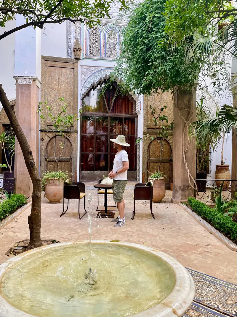 patio interior del Riad Larouusa con jardines y su fuente, con bonita decoración