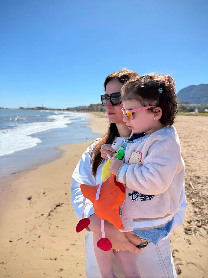 madre e hija disfrutan de la playa en primavera, con vistas al Montgo y mar mediterraneo, Denia