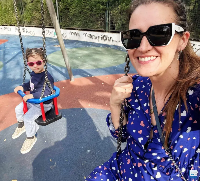detalle de mamá e hija en un parque infantil columpiandose en Denia