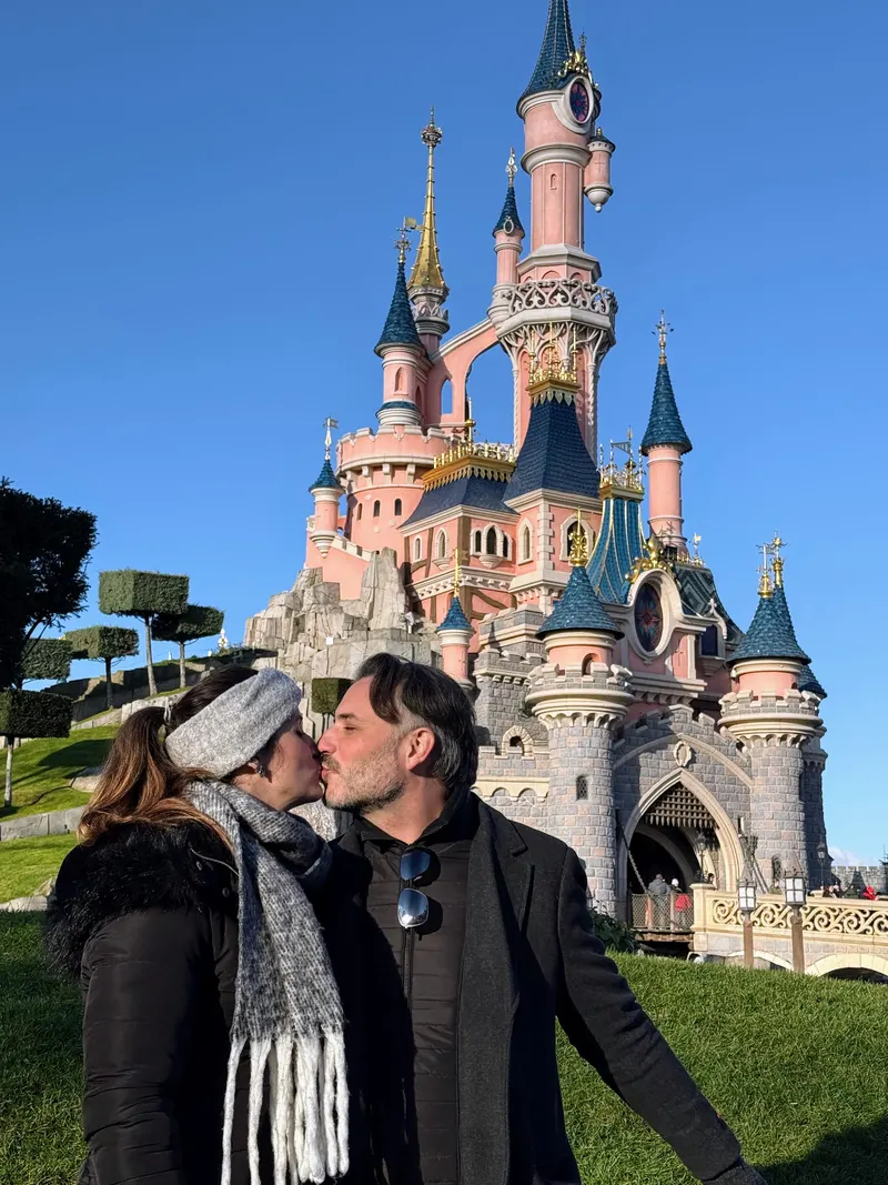 Pareja ante el castillo de la Bella Durmiente de Disneyland París en invierno