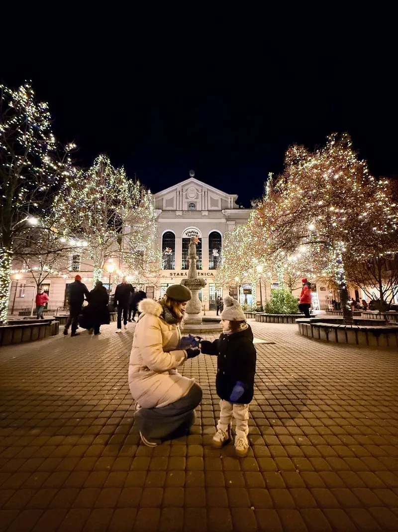 Madre e hija en el paseo de Hviezdoslavovo iluminado por Navidad, en Bratislava