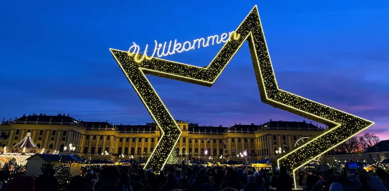 Estrella luminosa de bienvenida frente al palacio de Schönbrunn iluminado