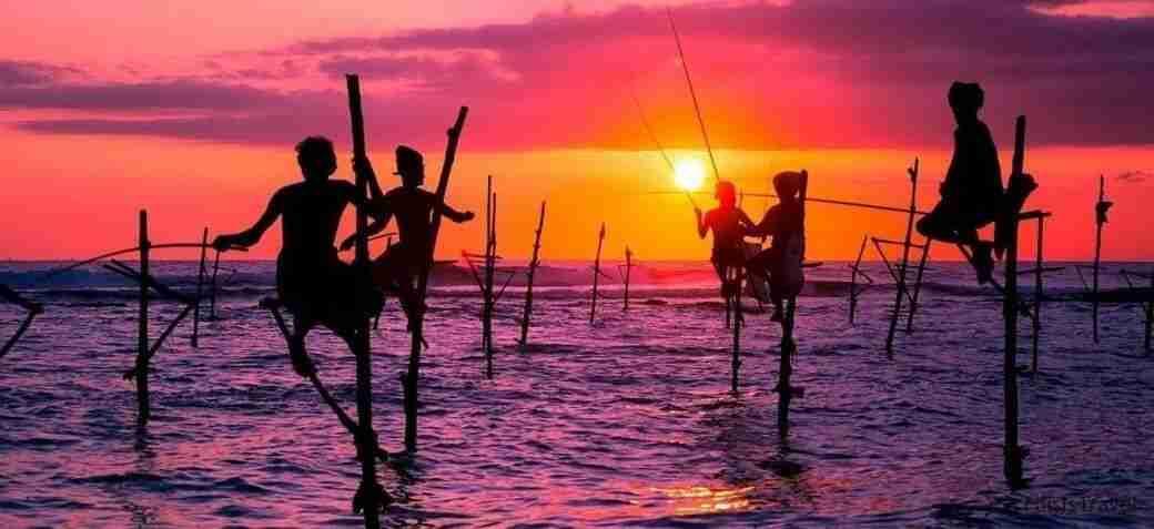 Pescadores tipicos de sri lanka sobre el mar con palos