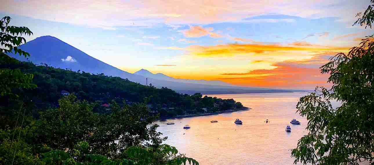 hermosa puesta de sol en Amed, Bali con el volcan Amung a lo lejos y sus tonos rojizos marinos
