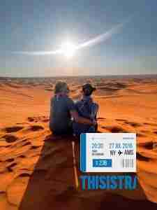 Pareja en las dunas del deiserto de Dubai al atardecer
