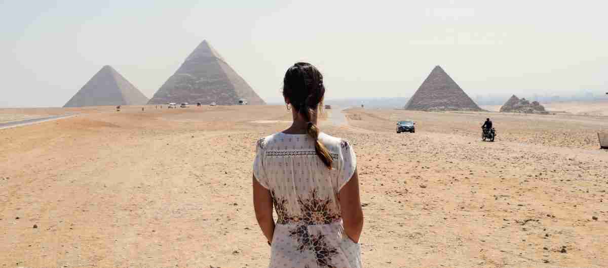 Chica frente a las impresionantes piramides de Guiza, Egipto
