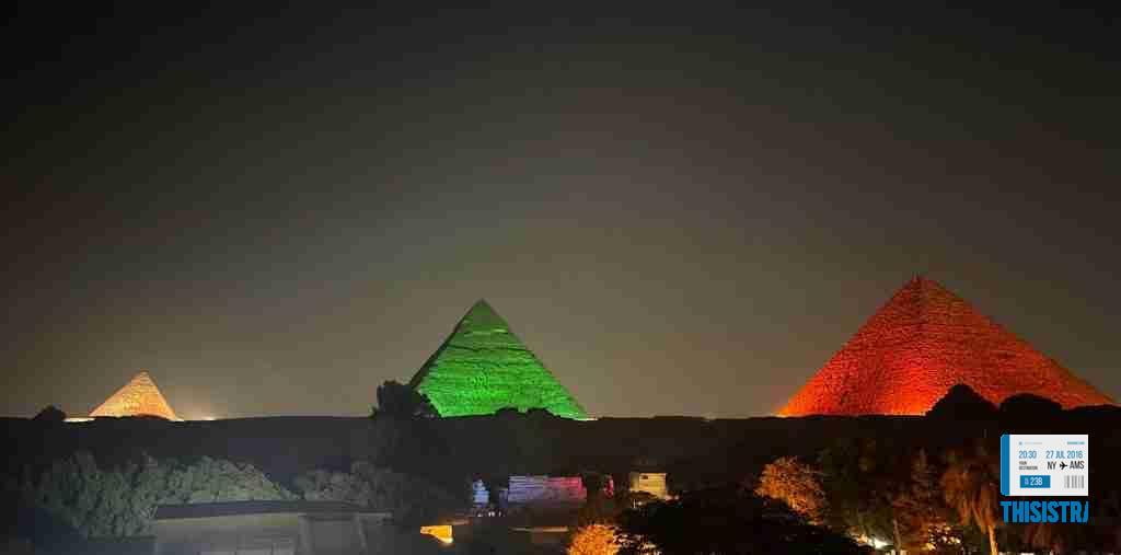Panoramica de las piramides de Giza iluminadas por la noche con diferentes colores, El Cairo, Egipto