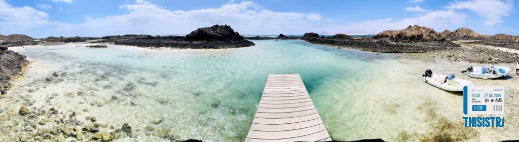 panoramica de la isla de Lobos con su formación volcánica y su puerto, agua turquesa