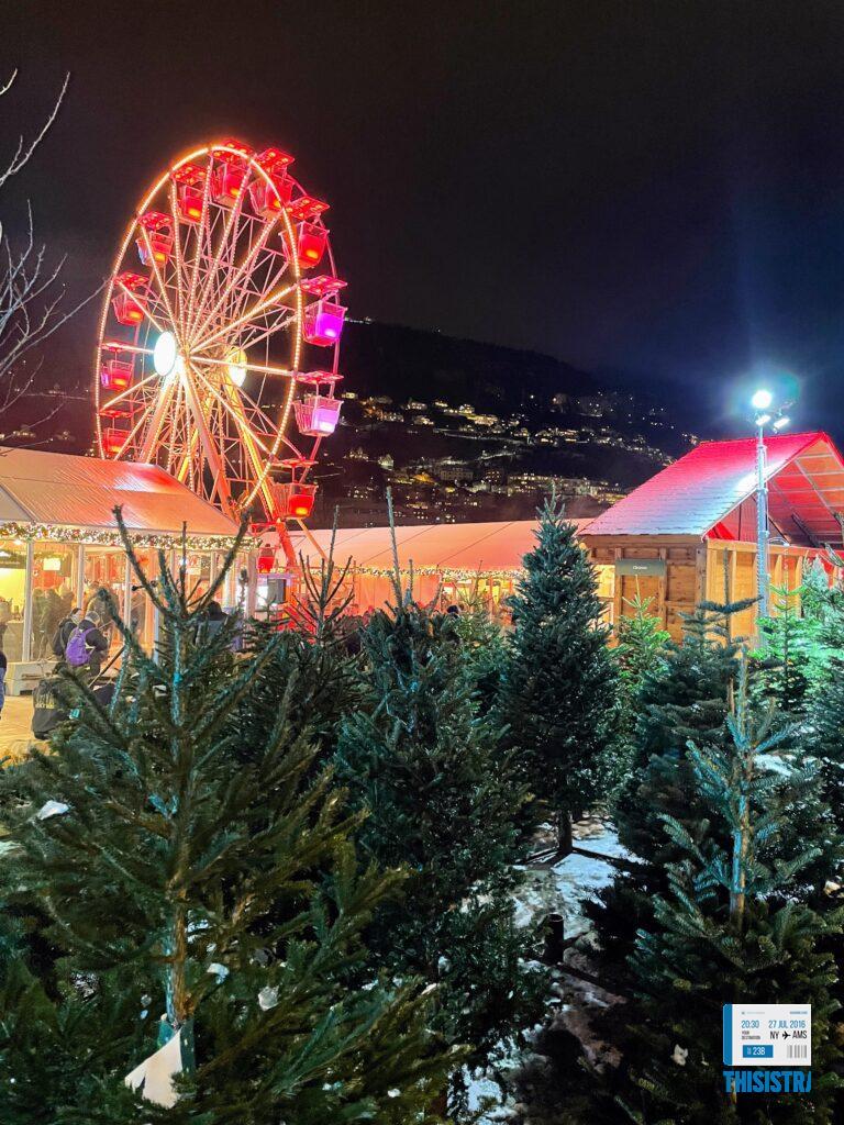 Mercado de Navidad de Bergen de noche, noria y tienda de abetos