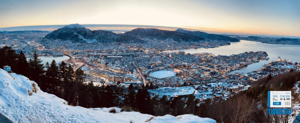 Puesta de sol de Bergen desde Monte Floyen con tonos violáceos y ciudad engalanada en navidad con nieve