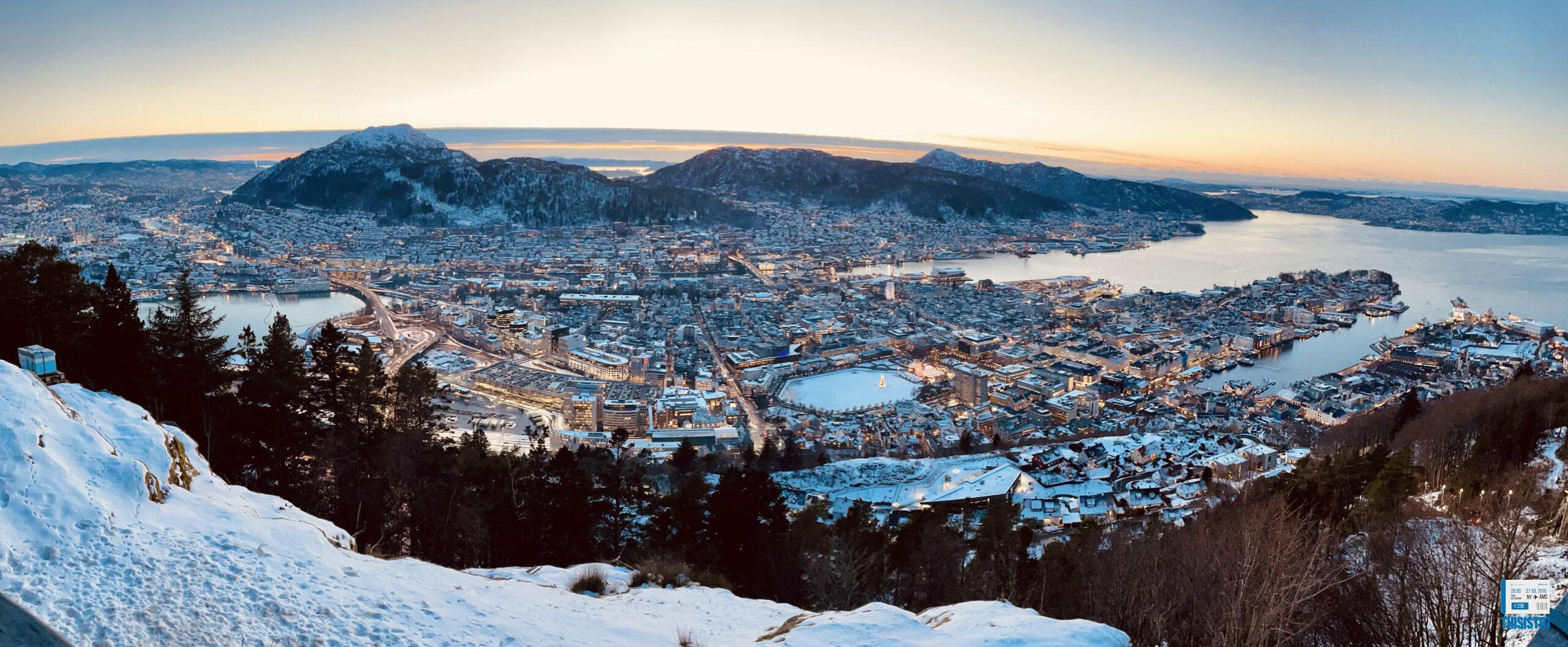 Puesta de sol de Bergen desde Monte Floyen con tonos violáceos y ciudad engalanada en navidad con nieve