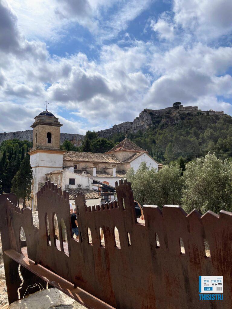 panoramica del castillo de Xàtiva, tras un banco con la panoramica de la ciudad