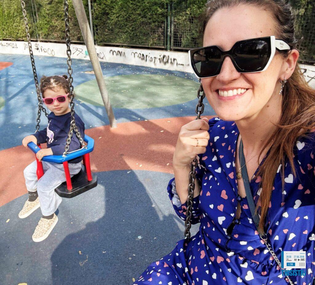 detalle de mamá e hija en un parque infantil columpiandose en Denia